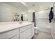 Bright bathroom featuring a large mirror, white vanity, and a shower-tub combo with tiled walls at 4792 E Shasta Dr, San Tan Valley, AZ 85143