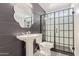 Stylishly updated bathroom featuring a pedestal sink, decorative mirror, and modern glass-enclosed shower at 4845 W Evans Dr, Glendale, AZ 85306