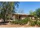 Cozy home surrounded by cacti and greenery, featuring a covered porch and desert landscape at 49478 W Val Vista Rd, Maricopa, AZ 85139