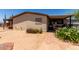 Tan home with a brick walkway leading to the screened-in porch, complemented by desert landscaping at 49478 W Val Vista Rd, Maricopa, AZ 85139