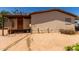 Beige single-story home with brown trim, showcasing a side entrance and gravel landscaping at 49478 W Val Vista Rd, Maricopa, AZ 85139