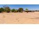 Wide view of a flat, dirt-covered lot featuring several outbuildings and mature trees in a rural setting at 49478 W Val Vista Rd, Maricopa, AZ 85139
