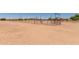 Expansive rural lot with metal fencing, mature trees, and sparse vegetation under a clear blue sky at 49478 W Val Vista Rd, Maricopa, AZ 85139