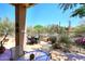 Scenic backyard showcasing desert landscaping and a cozy outdoor dining area with views at 6966 E Bramble Berry Ln, Scottsdale, AZ 85266
