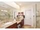 Bathroom featuring double sinks, granite countertops, a large mirror, and a glass-enclosed shower at 6966 E Bramble Berry Ln, Scottsdale, AZ 85266