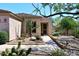 View of tan home with landscaped desert foliage leading to secure front door at 6966 E Bramble Berry Ln, Scottsdale, AZ 85266