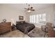 Comfortable main bedroom with plantation shutters, ceiling fan, and cozy sitting area at 6966 E Bramble Berry Ln, Scottsdale, AZ 85266