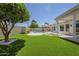 Beautiful backyard featuring artificial turf, mature trees, pool, and patio at 7144 E Lakeview Ave, Mesa, AZ 85209