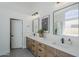 Bright bathroom featuring dual sinks, wooden drawers, contemporary lighting, and ensuite access at 7144 E Lakeview Ave, Mesa, AZ 85209