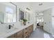 Bright bathroom featuring dual sinks, wooden drawers, contemporary lighting, and modern finishes at 7144 E Lakeview Ave, Mesa, AZ 85209