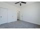 Neutral bedroom with ceiling fan, gray carpet, and white trim throughout at 7144 E Lakeview Ave, Mesa, AZ 85209