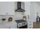 Contemporary kitchen features stainless steel range, white backsplash, and sleek black vent hood for modern cooking at 7144 E Lakeview Ave, Mesa, AZ 85209