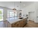 Kitchen island boasts barstool seating with sink, cabinet storage, and stainless steel appliances, creating a social hub at 7144 E Lakeview Ave, Mesa, AZ 85209
