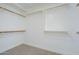 Bright walk-in closet featuring carpet, wooden shelving, and ample storage space at 7144 E Lakeview Ave, Mesa, AZ 85209