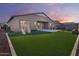 Large backyard featuring lush artificial turf, a playset, and a covered patio, ideal for outdoor activities and relaxation at 7694 W Desert Spoon Dr, Peoria, AZ 85383