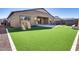 The large turfed backyard includes a play structure and outdoor seating, perfect for Gathering fun and entertaining at 7694 W Desert Spoon Dr, Peoria, AZ 85383