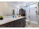 Bright bathroom features a spacious vanity, large mirror, and a walk-in shower with stylish shower curtain at 7694 W Desert Spoon Dr, Peoria, AZ 85383