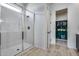 Modern bathroom features a glass-enclosed shower with white marble tile surround and wood look tile flooring leading to walk-in closet at 7694 W Desert Spoon Dr, Peoria, AZ 85383