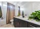Bathroom boasts a dark vanity with stone countertop, framed mirror, and tub with curtain at 7694 W Desert Spoon Dr, Peoria, AZ 85383