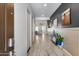 Inviting hallway with wood-look floors, neutral walls, and a charming decor, leading to various rooms at 7694 W Desert Spoon Dr, Peoria, AZ 85383
