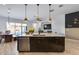 Spacious kitchen island with seating, stainless steel appliances, and modern pendant lights at 7694 W Desert Spoon Dr, Peoria, AZ 85383