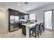 Modern kitchen features stainless steel appliances, a central island with bar seating, and stylish pendant lighting at 7694 W Desert Spoon Dr, Peoria, AZ 85383