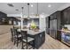 Gourmet kitchen with stainless steel appliances, an oversized island with breakfast bar, and stylish pendant lighting at 7694 W Desert Spoon Dr, Peoria, AZ 85383