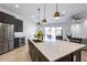 Open concept kitchen with a large island, pendant lighting, and stainless steel appliances at 7694 W Desert Spoon Dr, Peoria, AZ 85383