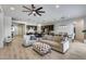 Spacious open-concept living area with modern tile floors, a ceiling fan, and seamless flow into the kitchen and dining at 7694 W Desert Spoon Dr, Peoria, AZ 85383