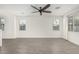Bright living room featuring wood-look tile flooring, ceiling fan, and natural light through large windows at 905 S Canal Dr # 17, Chandler, AZ 85225