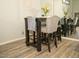 This dining area features a dark wood table with upholstered bar stools, modern decorations, and wood-style flooring at 9450 N 94Th Pl # 205, Scottsdale, AZ 85258