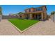 Inviting backyard with artificial grass, gravel, and a covered patio perfect for outdoor entertaining at 9752 E Torino Ave, Mesa, AZ 85212