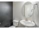 Powder room features modern fixtures, oval mirror and dark accent wall at 9752 E Torino Ave, Mesa, AZ 85212