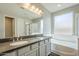 Well-lit bathroom with a double sink vanity, soaking tub, and a glass-enclosed shower at 9752 E Torino Ave, Mesa, AZ 85212