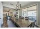 View of dining area with modern lighting, long wooden table, open to kitchen and living spaces at 9752 E Torino Ave, Mesa, AZ 85212