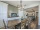 Dining room features modern lighting, long wooden table with seating, open to kitchen and living spaces at 9752 E Torino Ave, Mesa, AZ 85212