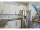 Bright kitchen features white cabinetry, herringbone tile backsplash, stainless steel appliances, and dark countertops at 9752 E Torino Ave, Mesa, AZ 85212