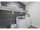 Laundry room with front load machines, storage shelf, and accent wall at 9752 E Torino Ave, Mesa, AZ 85212