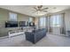 Comfortable living room with a gray sofa, ceiling fan, and wall-mounted TVs for entertainment at 9752 E Torino Ave, Mesa, AZ 85212