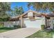 Home featuring a two-car garage, lush landscaping, and tile roof at 10023 E Sunnyslope Ln, Scottsdale, AZ 85258
