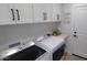 Laundry area featuring modern front load washer and dryer and white cabinetry at 10023 E Sunnyslope Ln, Scottsdale, AZ 85258