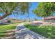 Lush community landscaping featuring mature trees and palms surrounds a winding concrete path at 10023 E Sunnyslope Ln, Scottsdale, AZ 85258