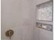 Modern shower features neutral tile, brass fixtures, and a convenient recessed niche at 10023 E Sunnyslope Ln, Scottsdale, AZ 85258