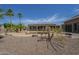Wide shot of the desert-landscaped backyard with the covered patio extending across the back of the house at 10033 W Jj Ranch Rd, Peoria, AZ 85383