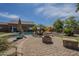 Backyard oasis with a pool, fire pit, and ample patio space for relaxation and entertainment at 10033 W Jj Ranch Rd, Peoria, AZ 85383