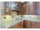 Close up of bar with granite counters, tile backsplash and glass front cabinets at 10033 W Jj Ranch Rd, Peoria, AZ 85383