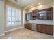 The elegant bar area offers custom cabinetry, wine cooler, and plantation shutters at 10033 W Jj Ranch Rd, Peoria, AZ 85383
