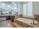 Bright bathroom featuring large tub, double sink vanity, and window at 10033 W Jj Ranch Rd, Peoria, AZ 85383