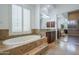 Bright bathroom featuring large tub, double sink vanity, and mirrored closet at 10033 W Jj Ranch Rd, Peoria, AZ 85383