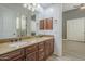 Bathroom featuring double sinks, granite countertop, wood cabinets, and large mirror at 10033 W Jj Ranch Rd, Peoria, AZ 85383